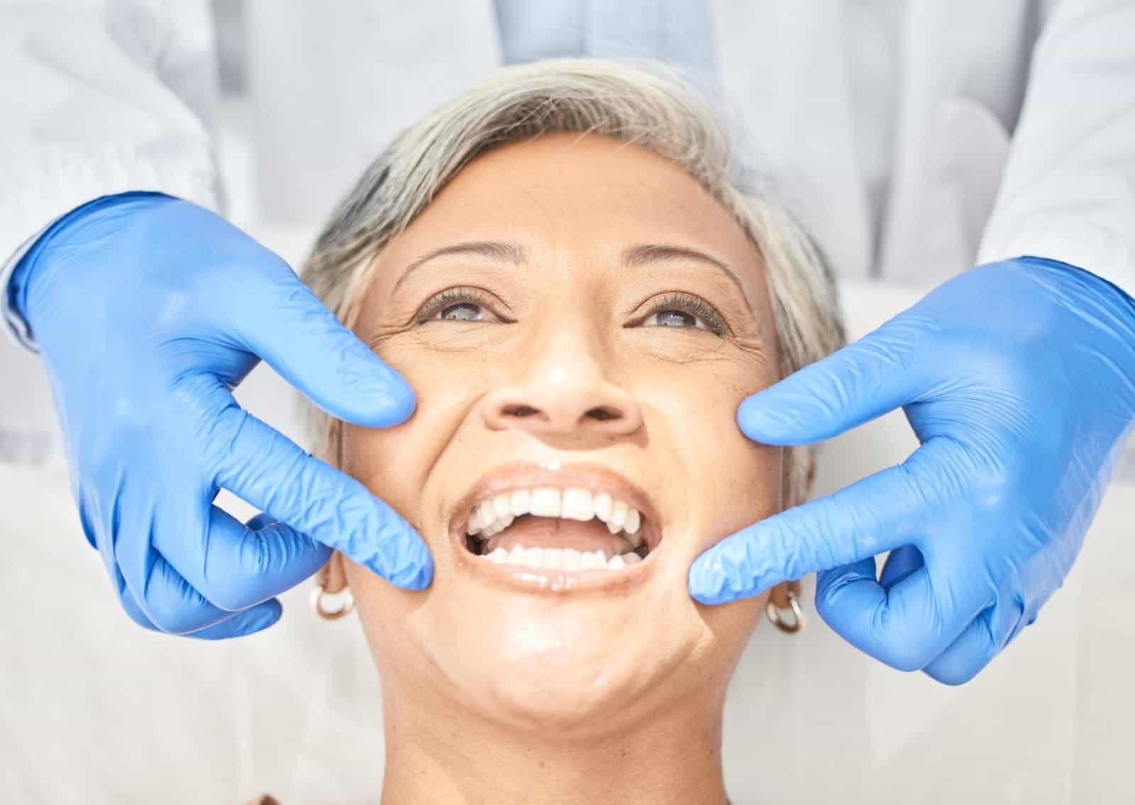 Senior woman, mouth and dentist hands with dental procedure, medical and healthcare with closeup. O.